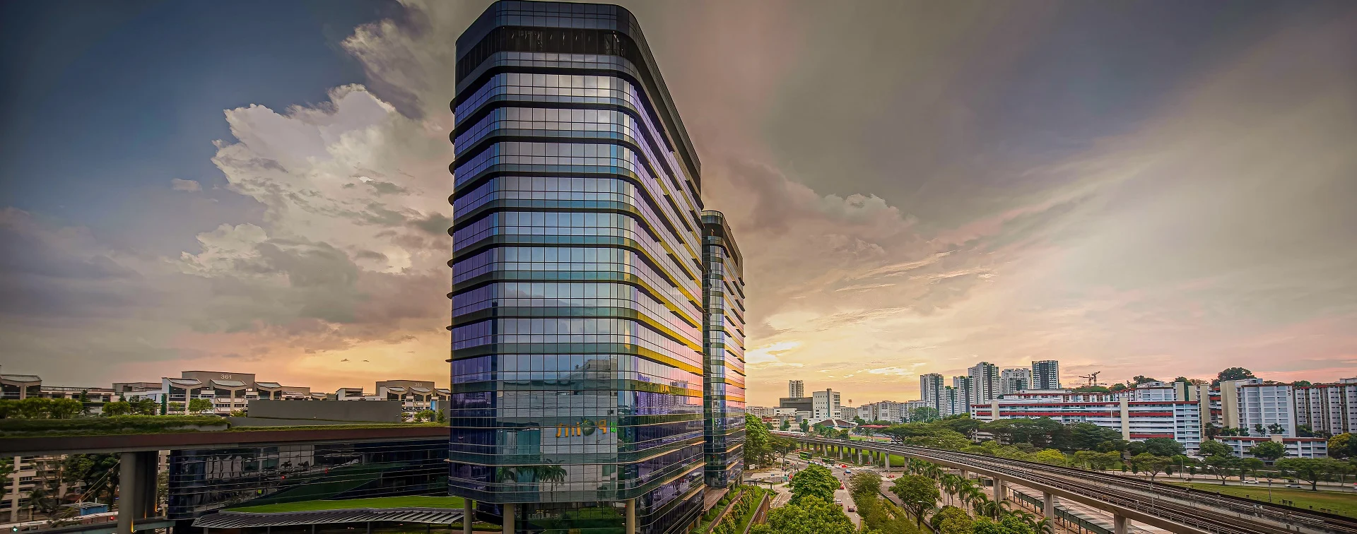 Woods Square office tower with Woodlands MRT track visible in foreground, Singapore